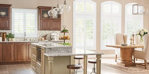 A kitchen with a sink and two stools in it