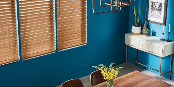 A dining room with blue walls and wooden blinds.