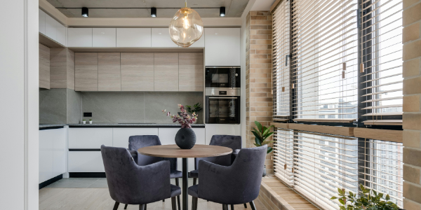 A table with four chairs in the middle of a kitchen.