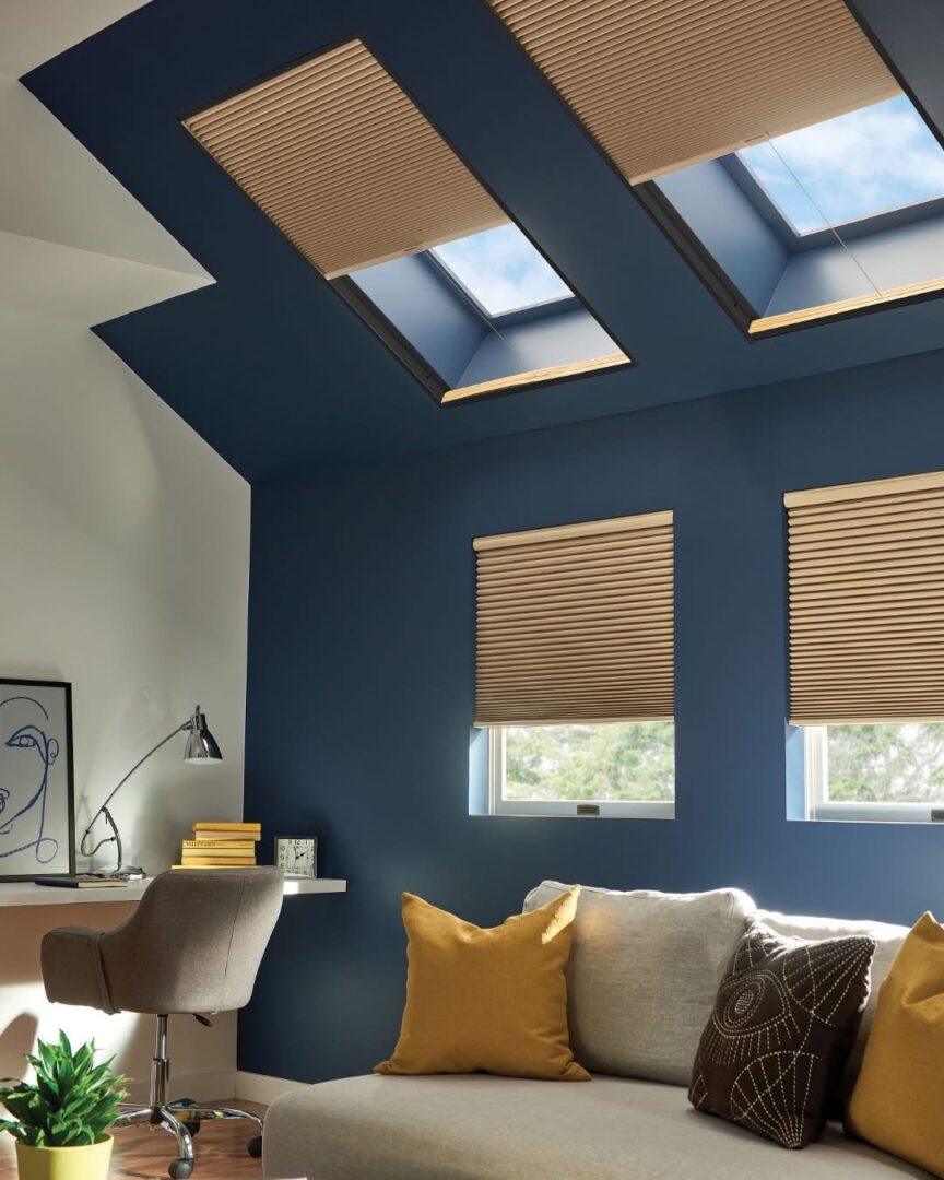 A living room with blue walls and yellow pillows.