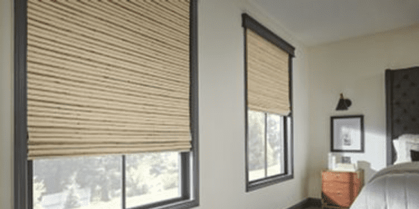 A room with two windows and blinds on the window.