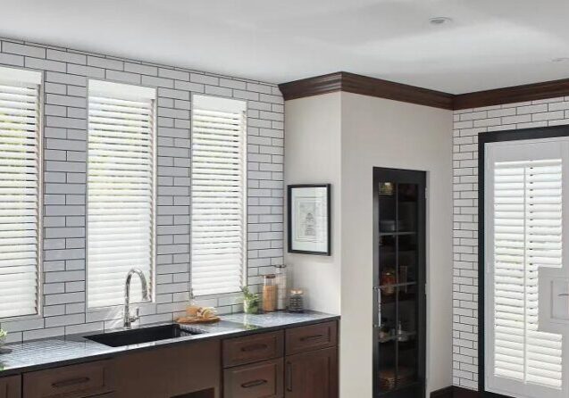 A kitchen with white brick walls and dark wood cabinets.