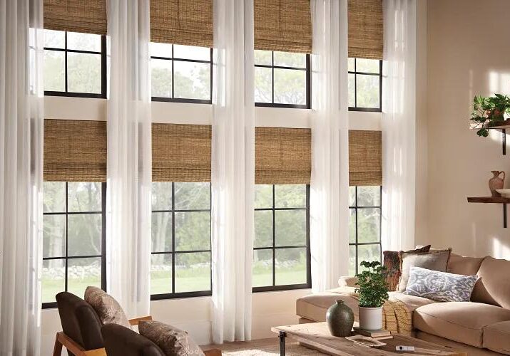 A living room with large windows and white curtains.